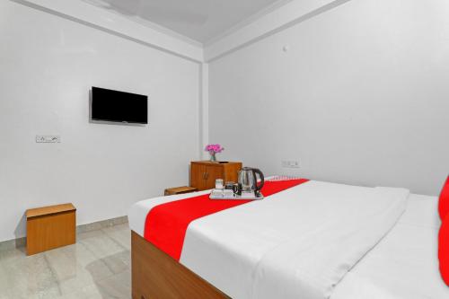 坎普爾的住宿－Flagship Sai Galaxy Hotel & Restaurant，一间卧室配有一张带红白毯子的床