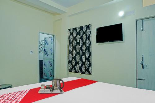 een slaapkamer met een bed met een rode deken bij Flagship Hotel Tulsi Inn in Dānāpur