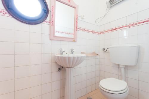 ein weißes Bad mit einem WC und einem Waschbecken in der Unterkunft Mar e terra casa rústica in São Pedro da Cadeira