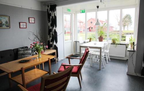 ein Esszimmer mit einem Tisch, einem Tisch und Stühlen in der Unterkunft Vadstena Folkhögskola Vandrarhem in Vadstena