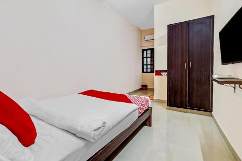 1 dormitorio con 1 cama y armario de madera en Collection O 45443 Hotel Suvidha en Bilāspur