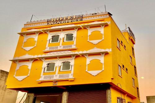 a yellow building with a sign on top of it at OYO Hotel Data Shree in Udaipur