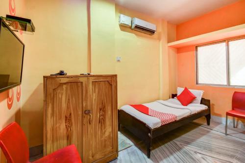 Habitación pequeña con cama y TV. en Super OYO Hotel Priyal Amrit Sagar, en Rourkela