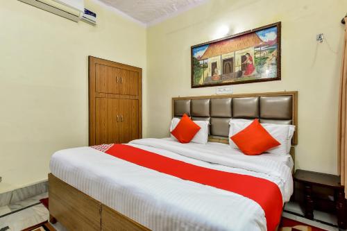 a bedroom with a large bed with orange pillows at Super OYO Dev Villas Guest House in Jodhpur