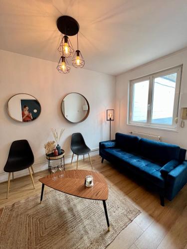 un salon avec un canapé bleu et une table dans l'établissement Duplex en plein cœur de Malo-Les-Bains, à Dunkerque