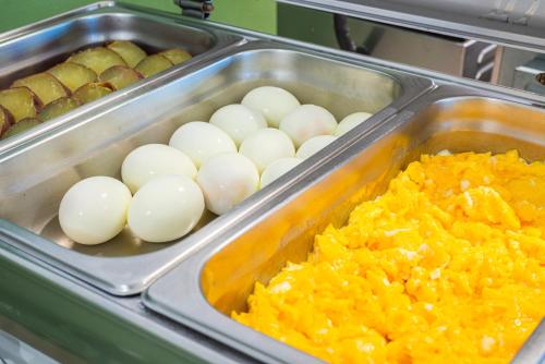 a tray of food with eggs and other foods at Hotel Melo in Balneário Camboriú