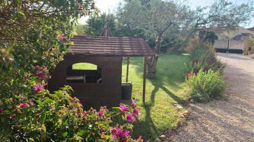 a small dog house in a yard with flowers at Villa les Pensées La Londe in La Londe-les-Maures