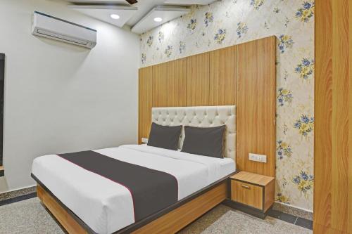 a bedroom with a large bed with a wooden headboard at Collection O Hotel Greenleaf in Jaipur