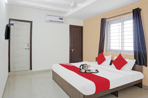 a bedroom with a large bed with red pillows at Super OYO Flagship Sapphire Homes Stay in Hinjewadi