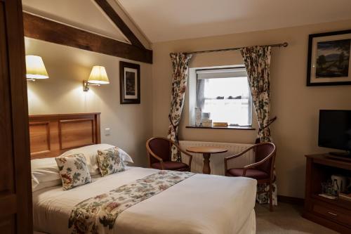 een hotelkamer met een bed en een televisie bij Oranmore in Ballymena