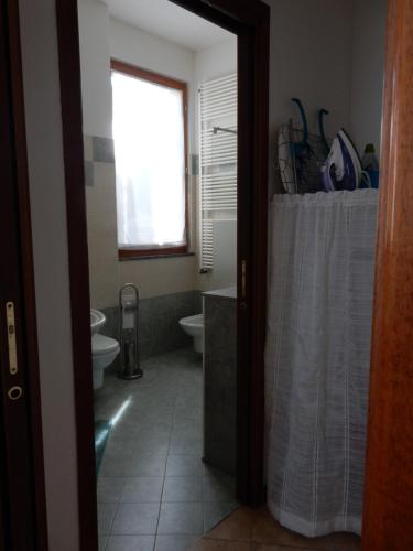 a bathroom with a sink and a toilet and a window at FiordiCasa - Appartamento vicino Rhofieramilano e Ospedale Galeazzi in Rho