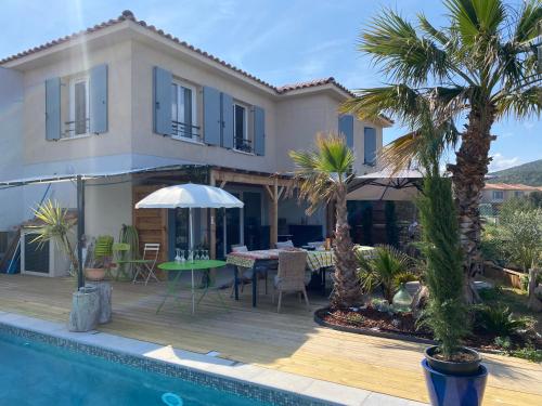 uma villa com piscina e palmeiras em Roquebrune Golfs Plages em Roquebrune-sur-Argens