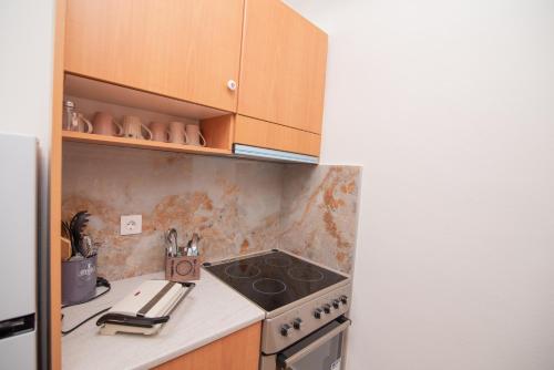 a kitchen with a stove top oven next to a refrigerator at Tsaner Apartment and Rooms in Matala
