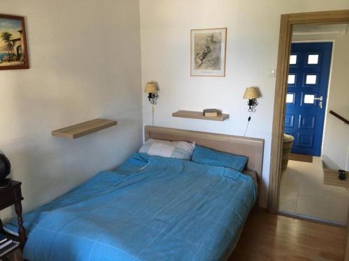 a bed in a bedroom with a blue comforter at Mediterranean Beach House in Perazića Do