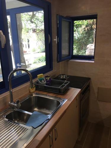 a kitchen with a sink and two windows at Mediterranean Beach House in Perazića Do