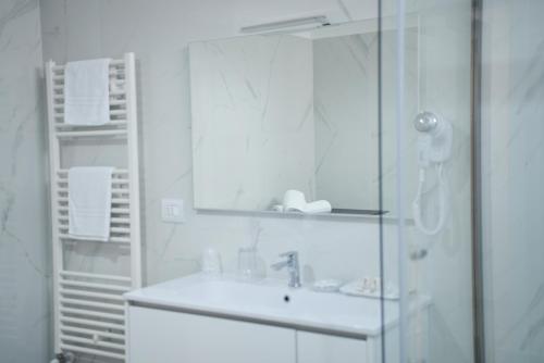 a white bathroom with a sink and a mirror at La Casa di Eva in Brindisi