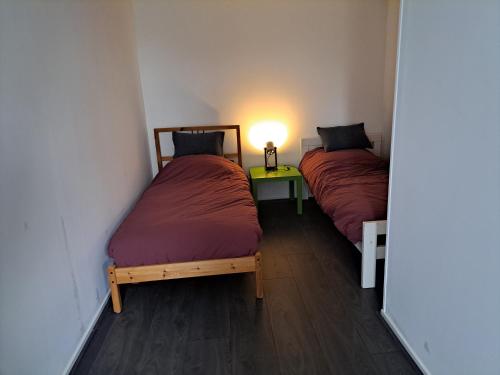 - 2 lits dans une chambre avec une lampe sur une table dans l'établissement vakantiehuisje De achte, à Wommels