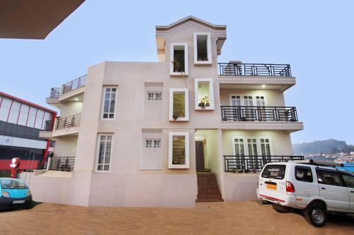 a white van parked in front of a house at OYO Home Stay Fable Stay in Ooty