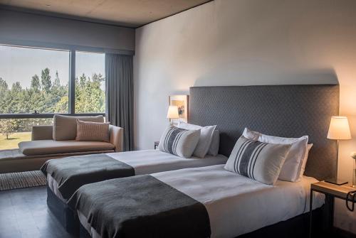 a hotel room with two beds and a large window at KOS Pilar Hotel in Pilar