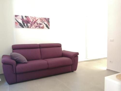 un sofá púrpura en una sala de estar en Casa Clementina en Pisa