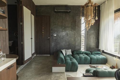a living room with a green couch in a room at Luxury Villa Ocean View "Casa Mar" in Holbox Island