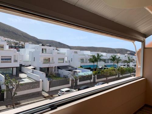 een uitzicht op een stad vanuit een raam bij Los Cristianos Apartamento en residencial Los Seres in Los Cristianos