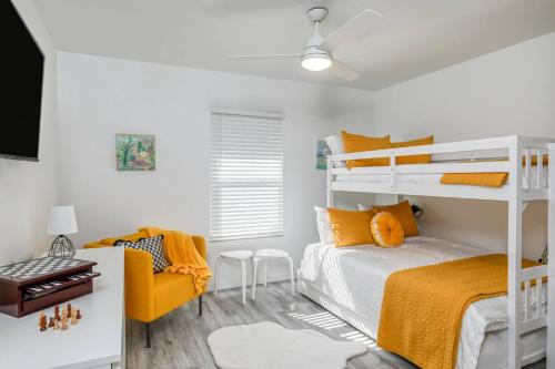een slaapkamer met een stapelbed en een gele stoel bij River's Edge Retreat in St. Augustine