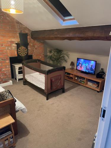 a living room with a bed and a tv at Dove House in Congleton