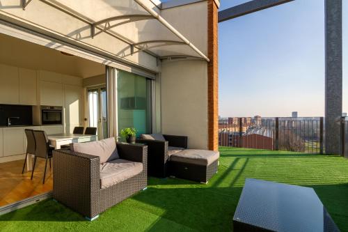 a living room with a balcony with green grass at Terrazza Panoramica SleepInMilan in Sesto San Giovanni