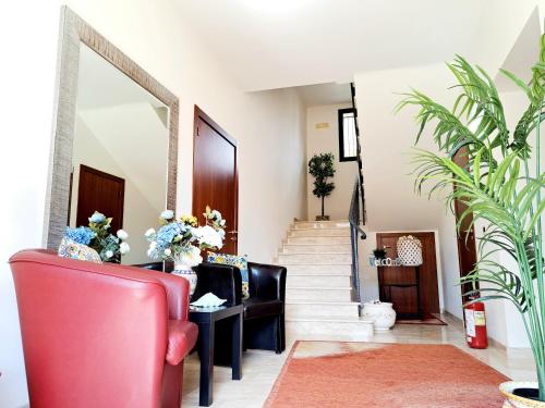 a living room with a red chair and stairs at Appartamento Castel Sant'Angelo in Licata