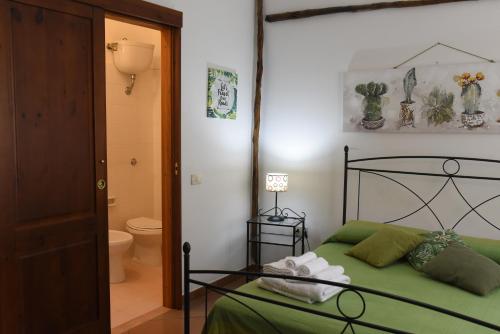 a bedroom with a green bed and a bathroom at Hotel California in Carloforte