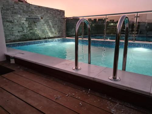 a swimming pool with three metal bars around it at Cazinos Apartamento in Praia