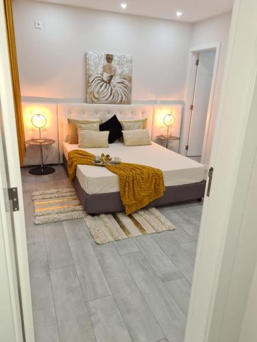 a bedroom with a large bed and two lamps at Résidence Cazino Apartamentos in Praia