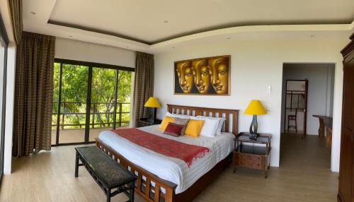 ein Schlafzimmer mit einem großen Bett und einem Balkon in der Unterkunft Fah Suay Villa - Incredible & Spacious 5 Bedrooms in Mae Nam