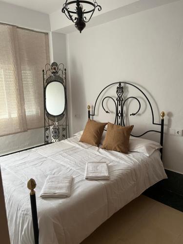 a bedroom with a white bed with two books on it at El Torreón 2 in Lora del Río