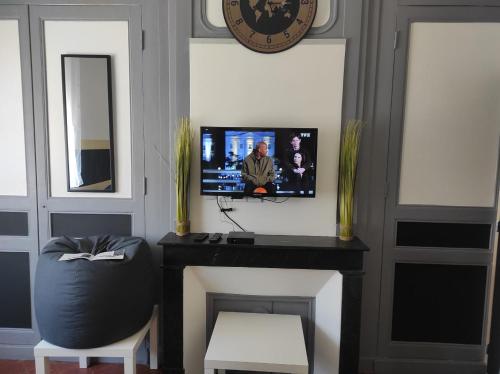 a room with a tv and a table and a chair at maison julius aeroport tillé 2 a 4 personnes in Tillé
