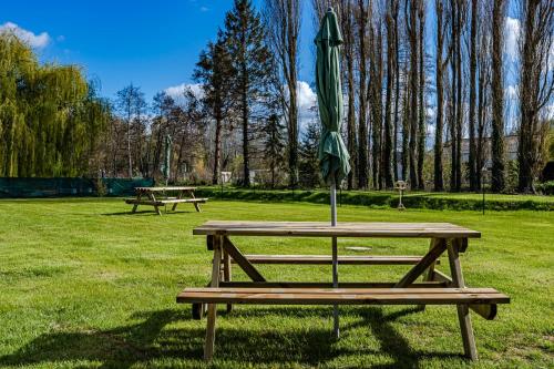 a picnic table with an umbrella on it in a park at L’odon in Caen