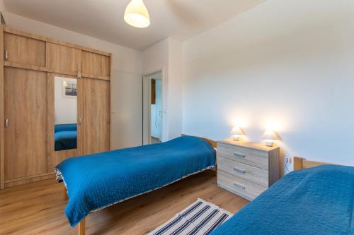 1 dormitorio con 2 camas y vestidor con sábanas azules en Mljet, old stone apartment with pool in nature en Babino Polje