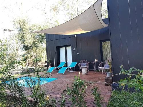 eine Terrasse mit blauen Stühlen und einem Gebäude in der Unterkunft La Pausa Casa Rural in A. de la Cruz