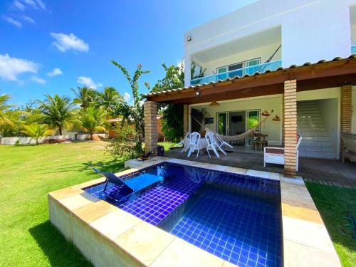 een villa met zwembad voor een huis bij Ville Santorinni in Japaratinga