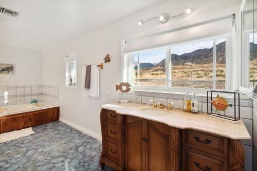 a bathroom with a sink and a window and a tub at The Big Sky in Pearblossom