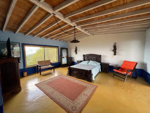 a bedroom with a bed and a table and chairs at Hacienda Palomas en Concordia - Finca Cafetera in Salgar
