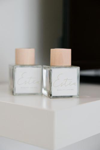 two candles in glass containers sitting on a table at ESTEA Quality Living in Volos