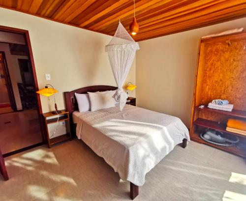 Schlafzimmer mit einem Bett mit Moskitonetz in der Unterkunft Casa Iluminalia in Abraão