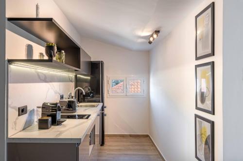 a kitchen with white walls and a counter at Grouzi Loft in Skala Kefalonias