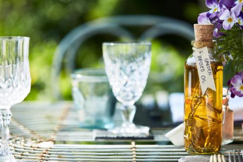 a table with glasses and a bottle of essential oils at Pear Tree Inn Whitley in Whitley