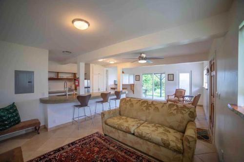 a living room with a couch and a kitchen at Hana Homestead in Hana