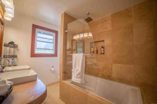 a bathroom with a shower and a sink and a tub at Hana Homestead in Hana