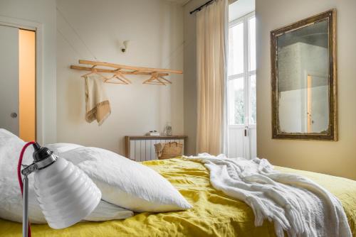a bedroom with a bed with yellow sheets and a mirror at LE SECRET in Saint-Martin-de-Ré