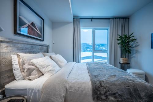 a bedroom with a large bed and a large window at Lago 55 by Tremblant Platinum in Mont-Tremblant